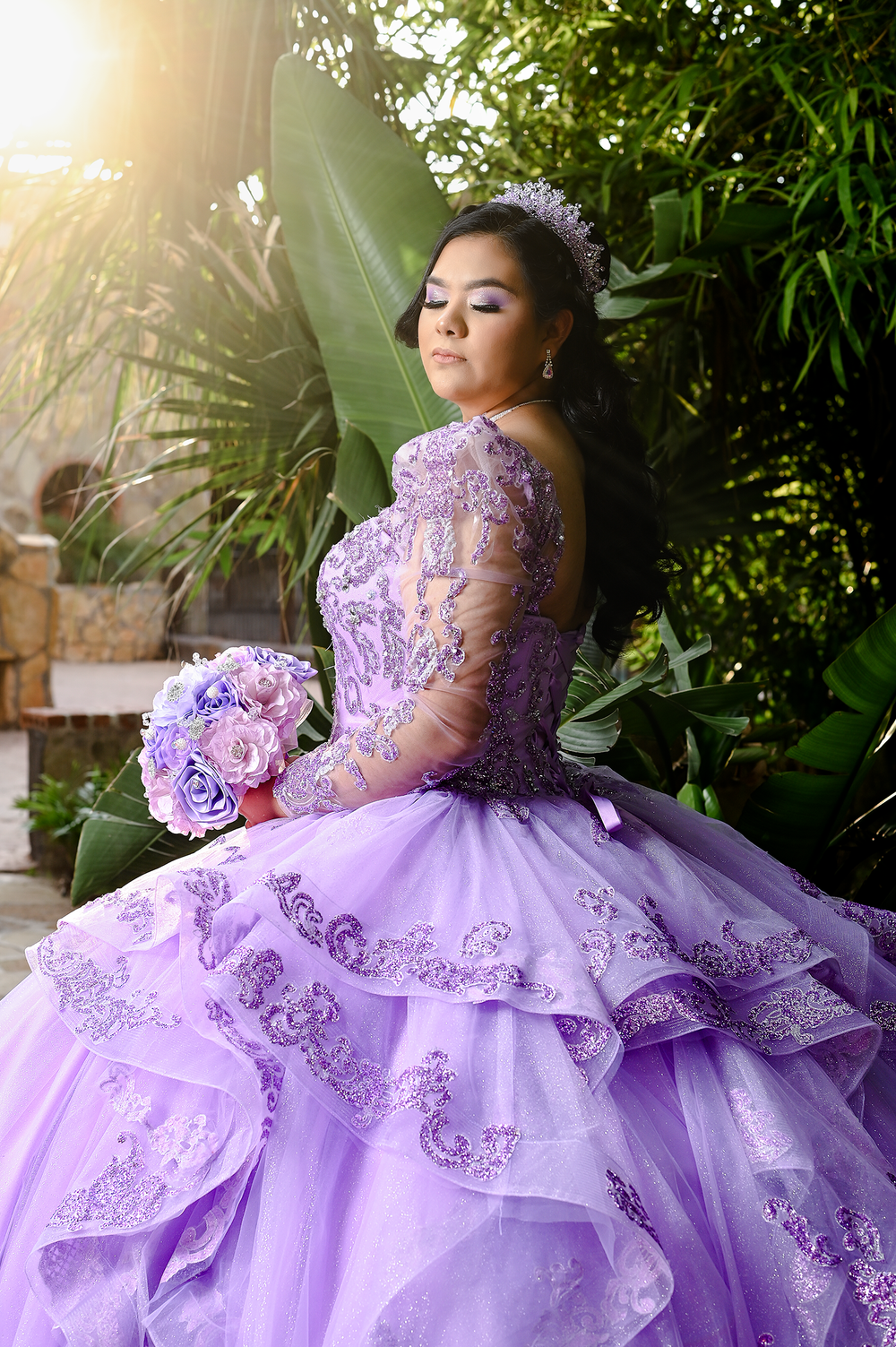 Stunning lilac quinceanera dress with lace details captured in golden sunlight.