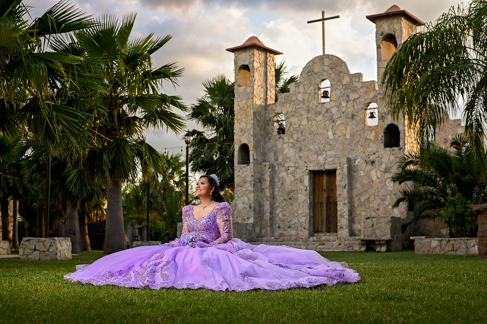 Dramatic purple ballgown photographed in front of Spanish-style mission church.