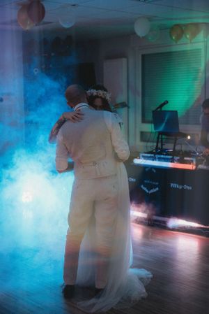 A romantic dance moment captured with atmospheric smoke and colored lighting effects.