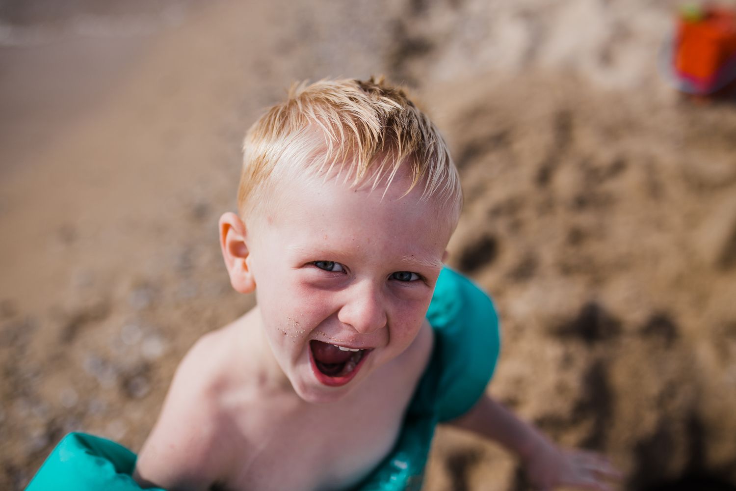 A joyful summer beach moment captured with sand and blue water in the background.