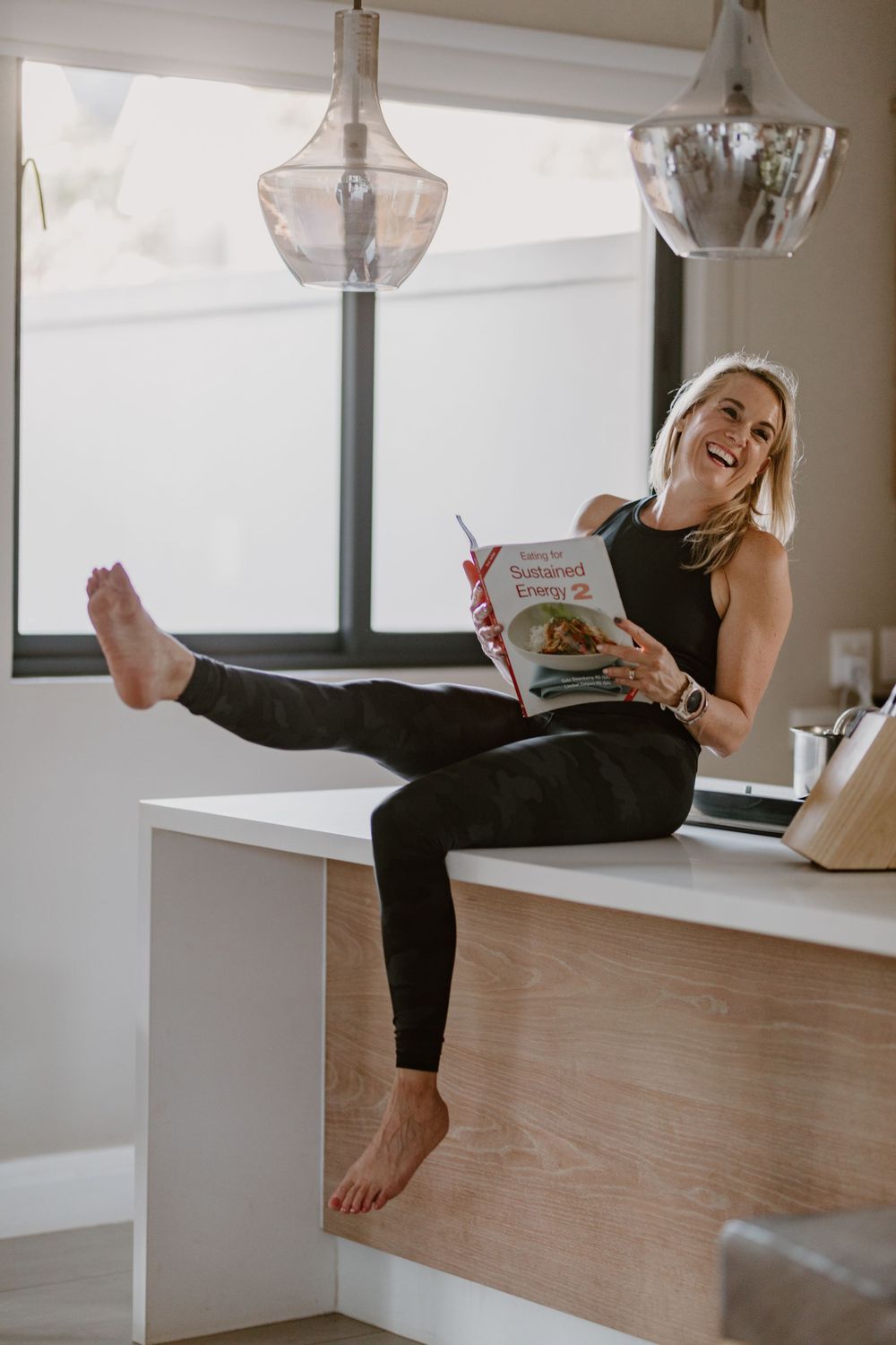 lady reading book on kitchen counter