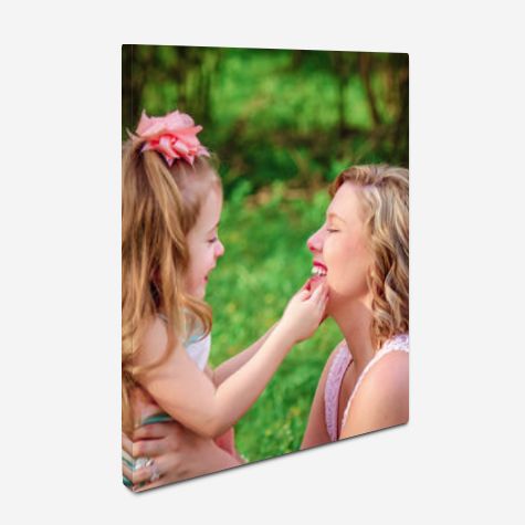 Canvas print showing tender mother-daughter moment outdoors with green background.