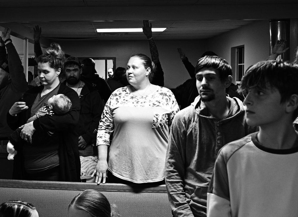 Students gathered in a classroom watching intently in black and white photograph.
