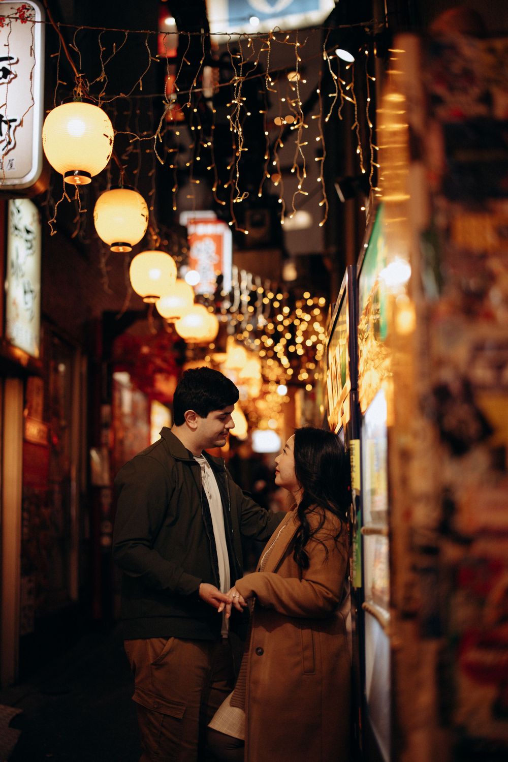 A romantic evening scene with paper lanterns and string lights illuminating a cozy street in Japan.