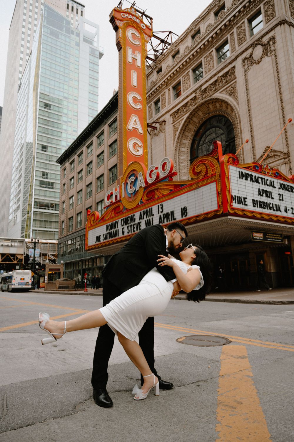 A romantic dip pose in front of the iconic Chicago Theatre's illuminated marquee.