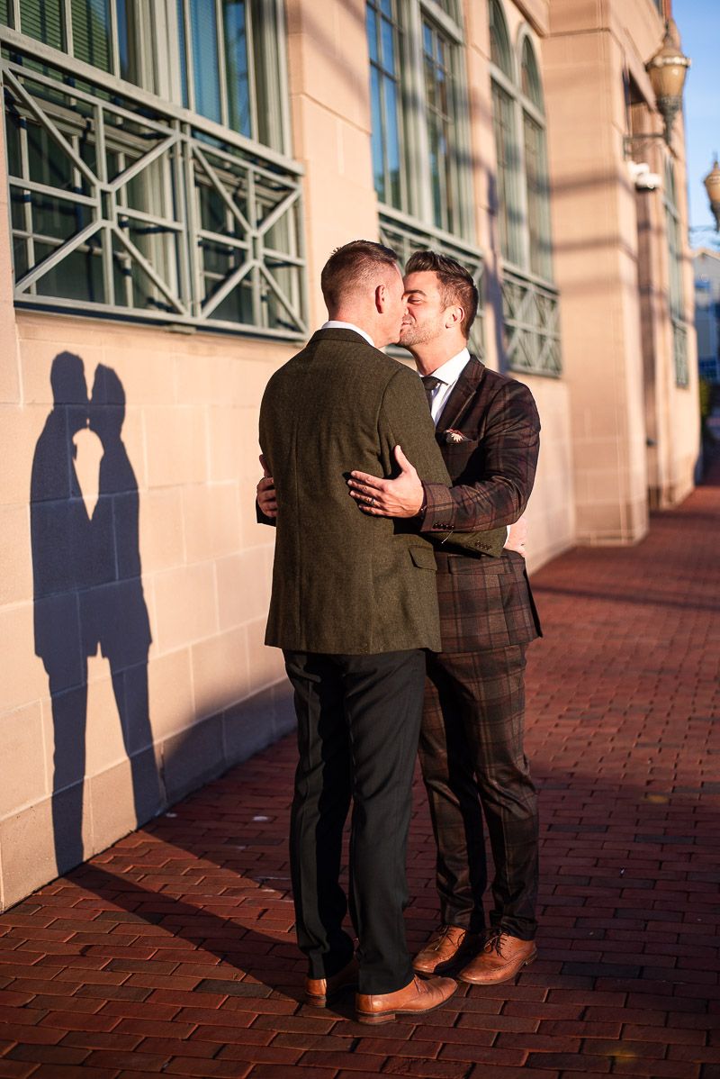 Intimate moment captured with mountain landscape and pasture fencing in background.