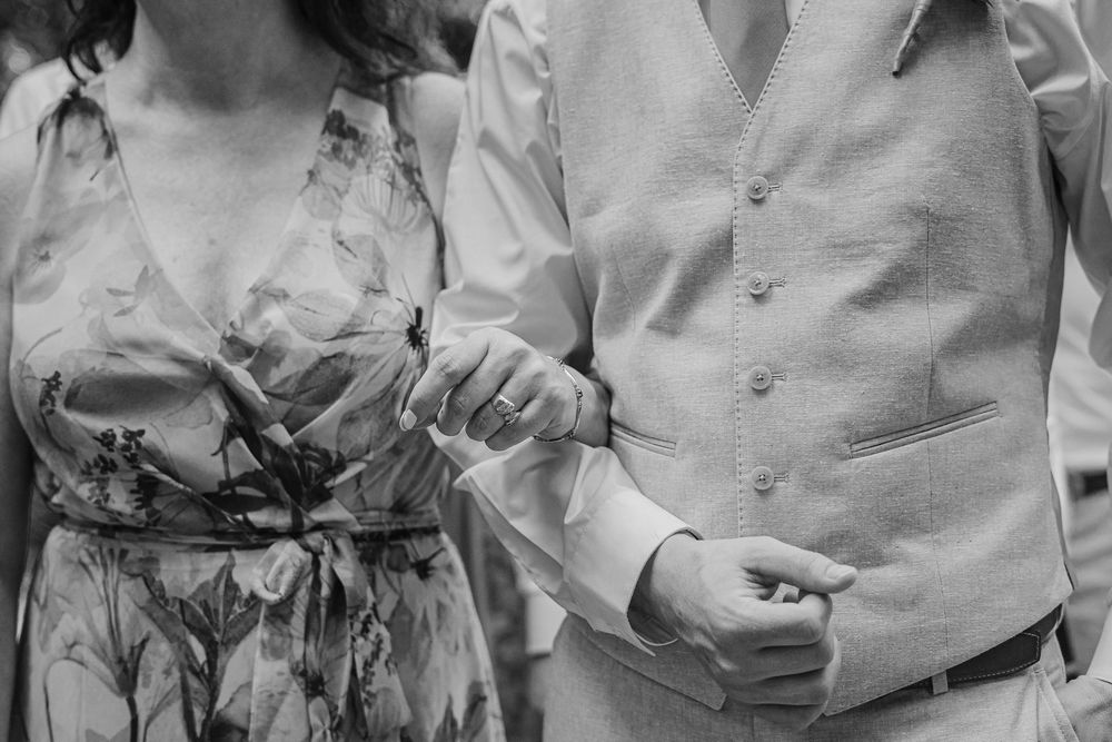 Black and white close-up of couple holding hands showing wedding attire details, Sandos Caracol Wedding.