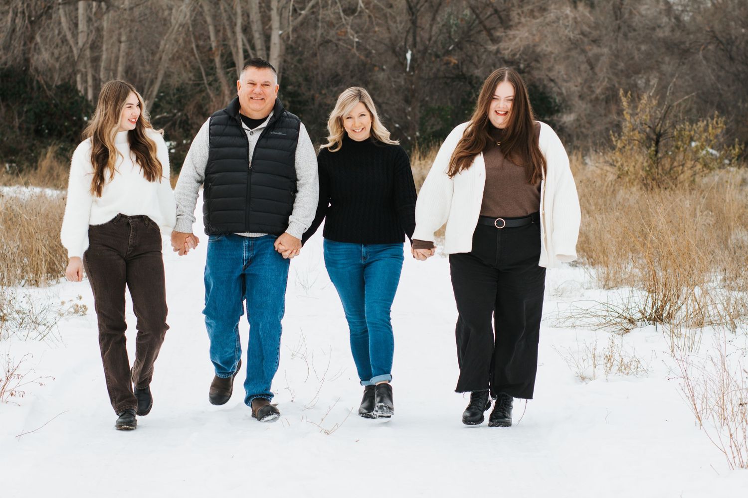 Family walking through snowy winter landscape at Zintel Canyon in Kennewick, Washington.