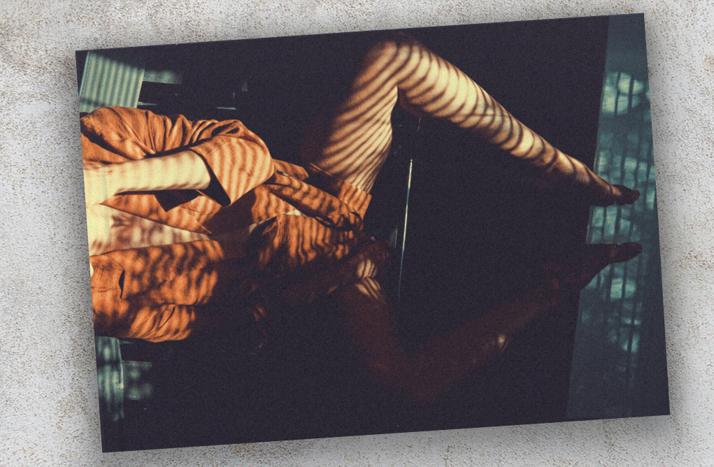 Artistic photograph of orange-lit architectural forms creating geometric patterns in darkness.