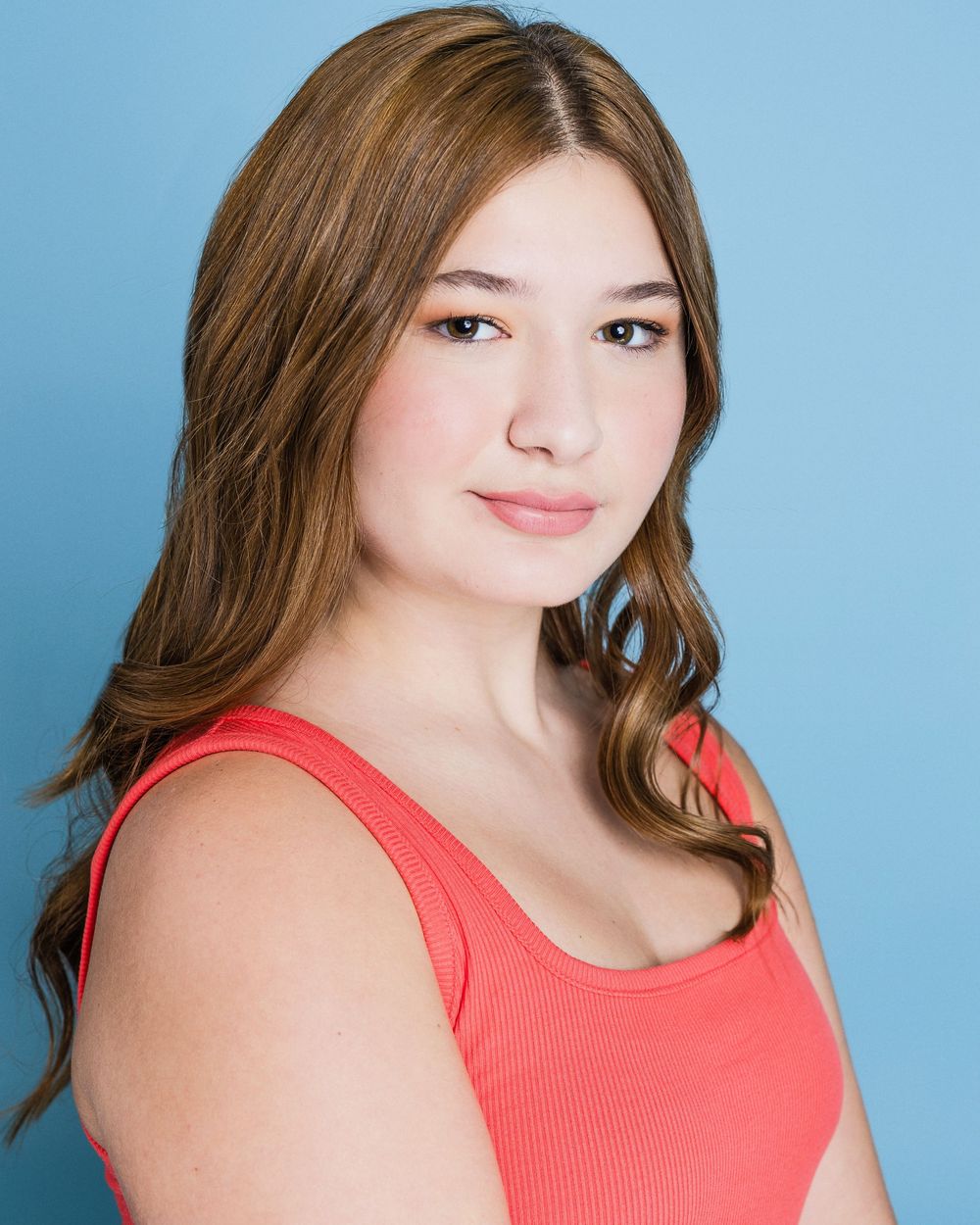 A series of headshot portraits shot against a blue background in a coral colored tank top.