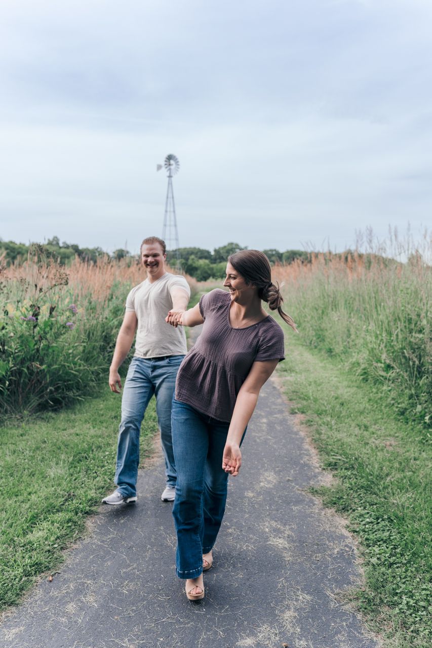 A couple walks along a paved trail with a windmill visible in the distance. Marion, Ohio