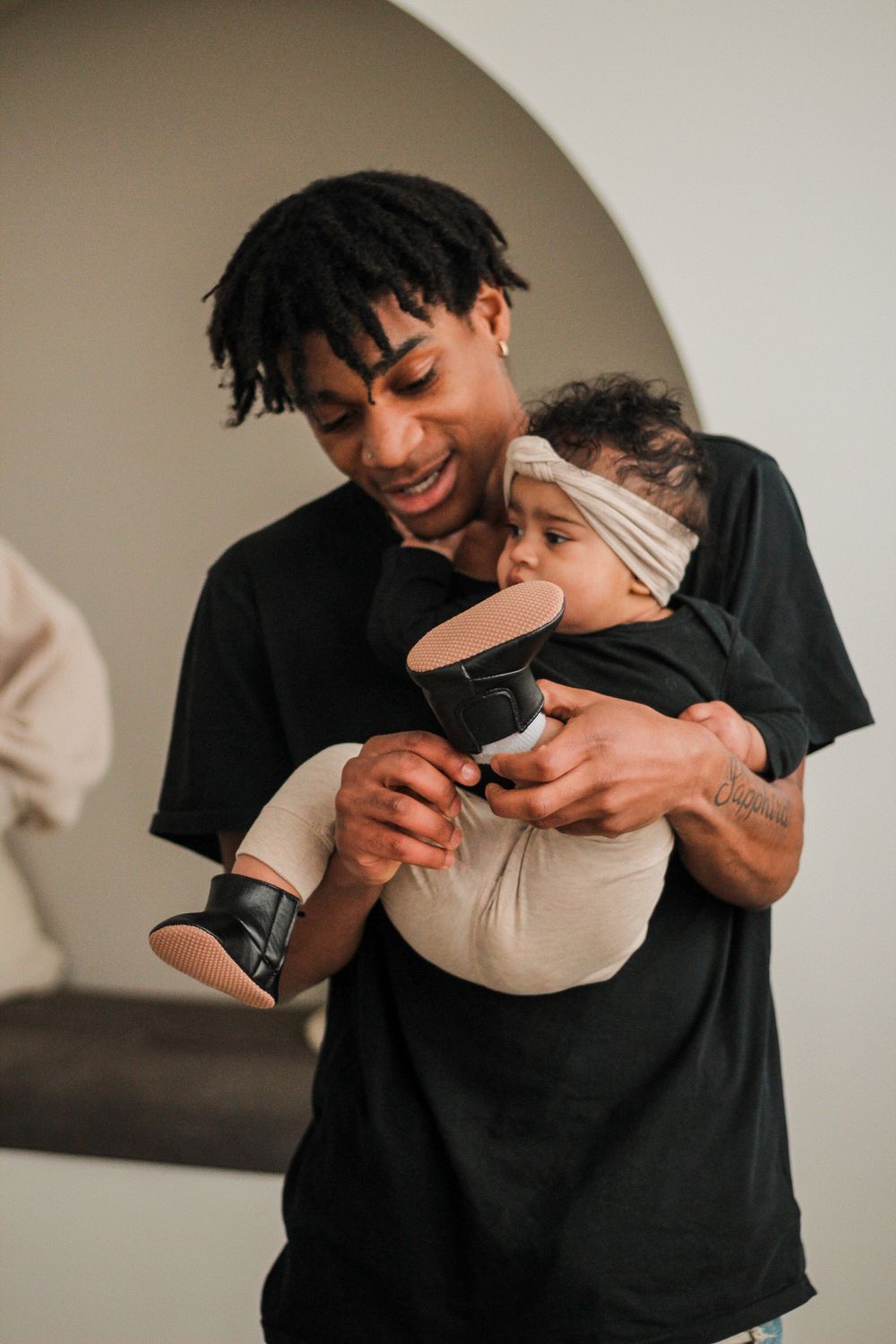 Family photography of a black father holding her baby daughter.