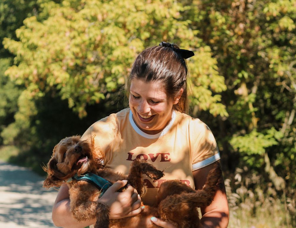 Family photography of a woman holding her brown puppy.