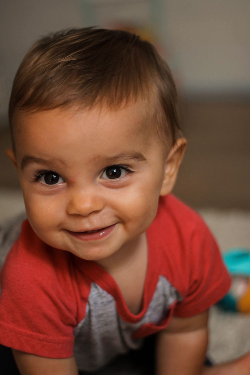 Family photoshoot of a baby crawling and smiling.