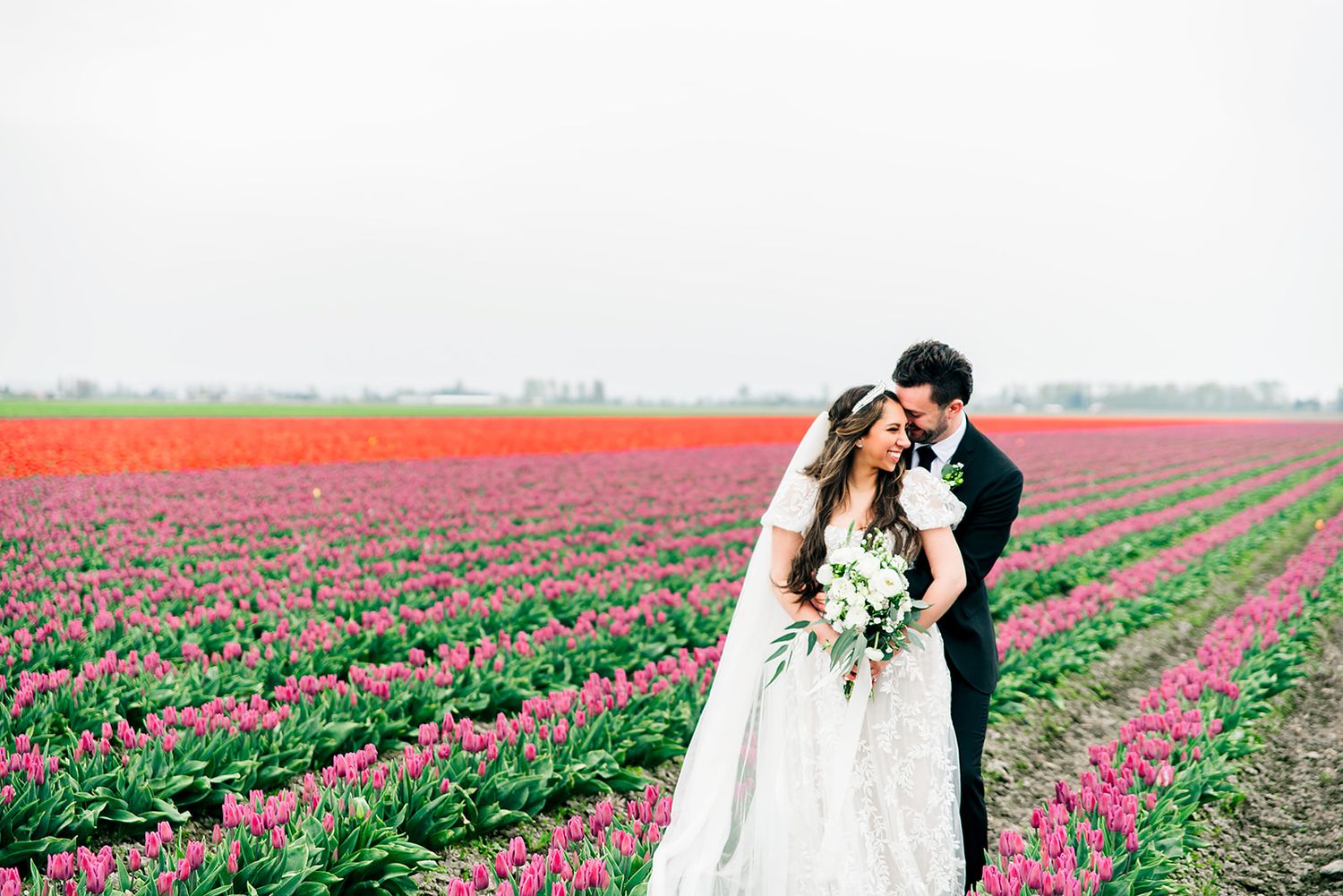 Wedding photos taken in vibrant tulip fields with colorful rows of flowers.
