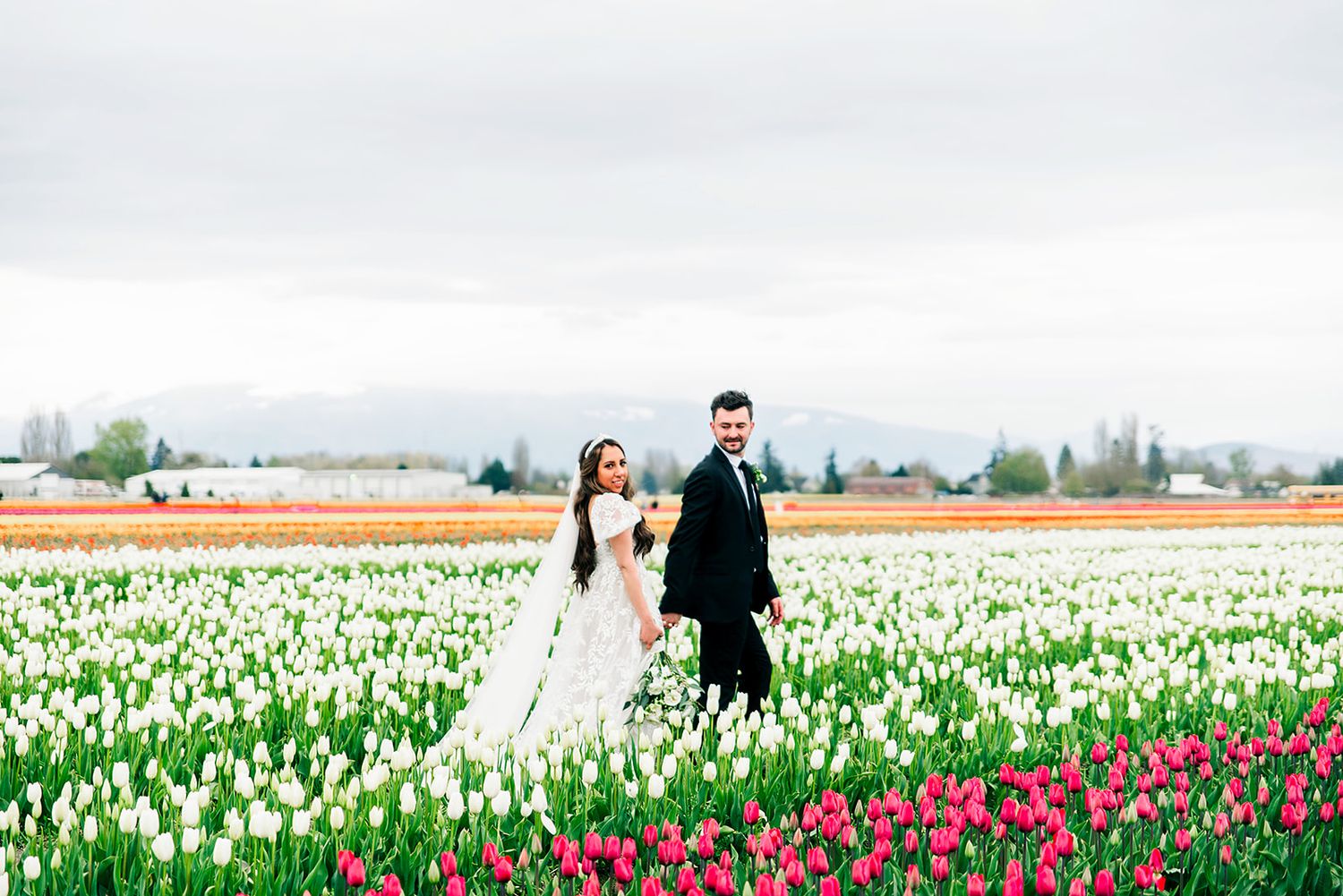 Romantic portraits captured in blooming tulip fields with white and red flowers.