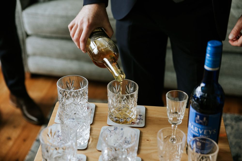 Crystal glasses lined up on a wooden table for a wedding toast.