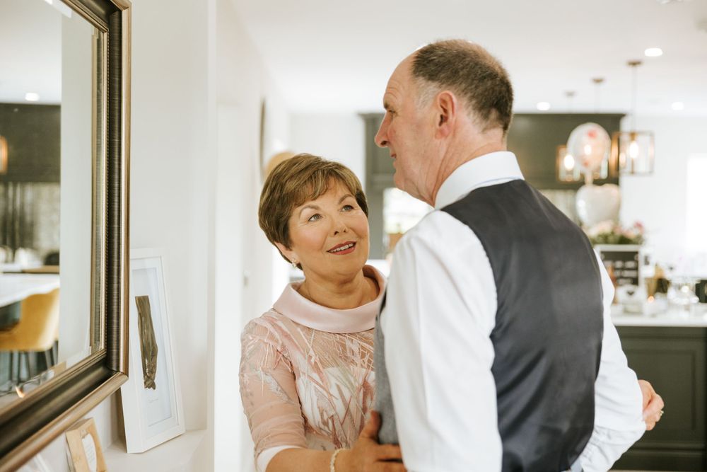 Wedding party members share joyful moments in a bright indoor setting.