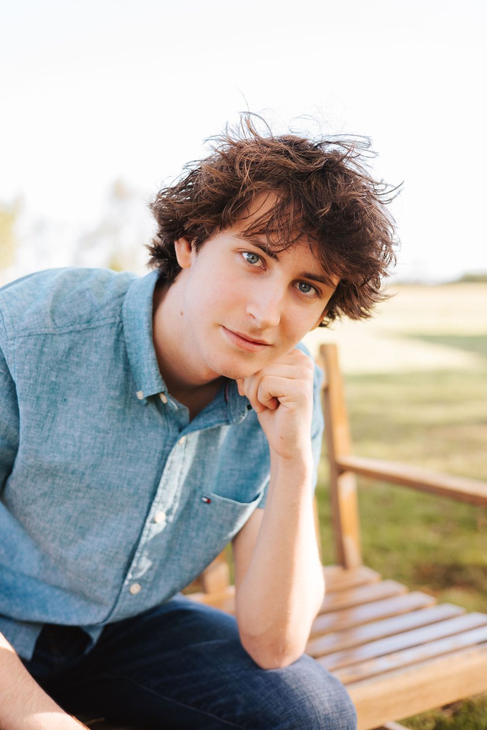 Casual portrait series on wooden bench showing relaxed poses in denim shirt.