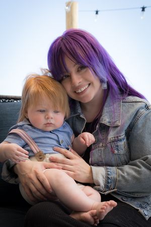 A series of five candid photos showing tender moments between a baby and someone with purple hair in a denim jacket.