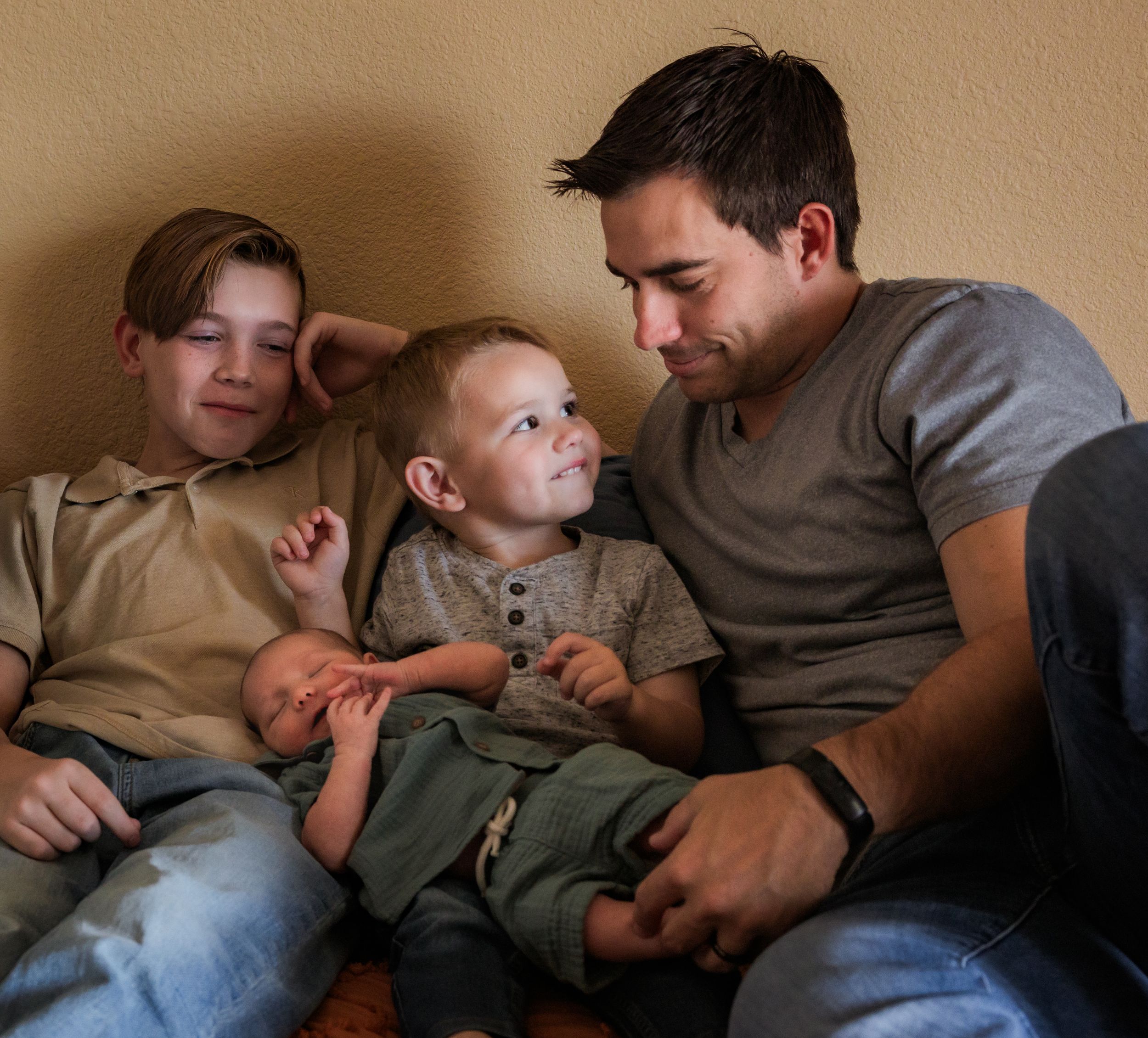 A tender family moment shows a parent and two children relaxing together