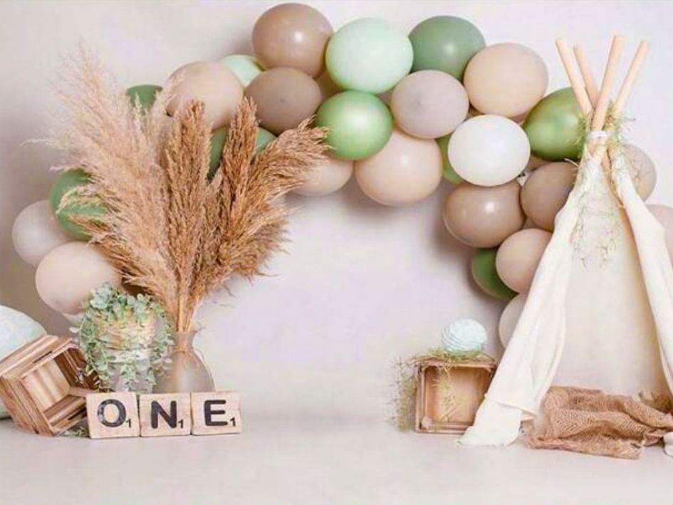 Boho birthday decoration with pastel balloons and teepee tent.