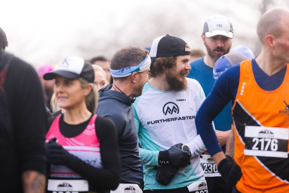 Group of runners participating in a marathon race wearing race bibs and athletic gear.
