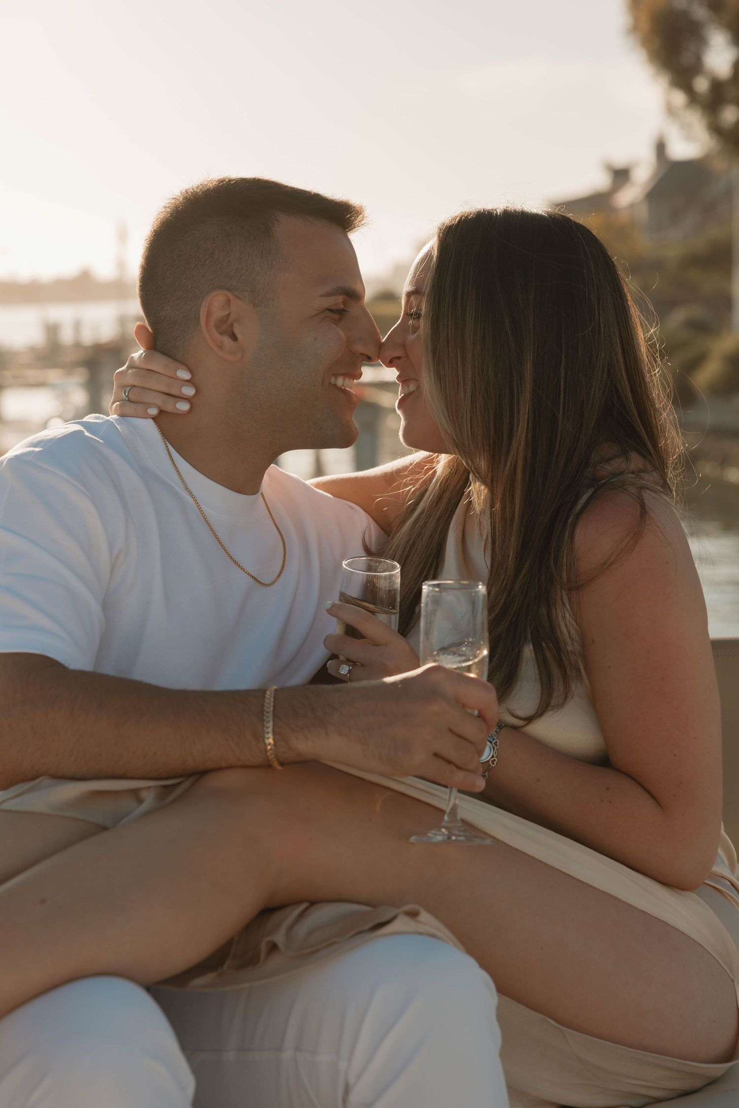 Romantic couple sharing drinks and intimate moment at sunset on a yacht in Newport Beach