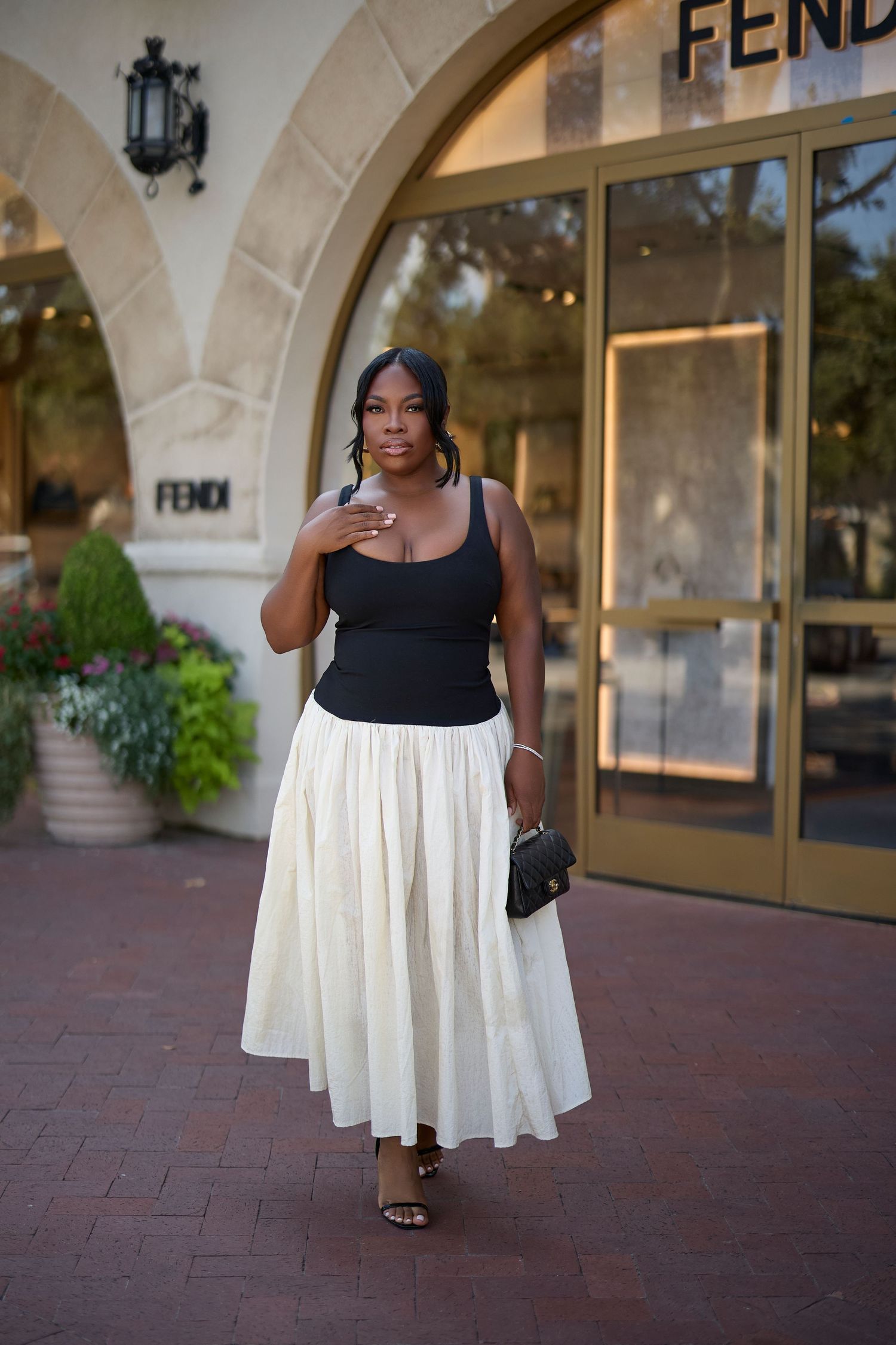 Fashion photography outside a Fendi store featuring a black and white contrast dress. Crystal Chanel