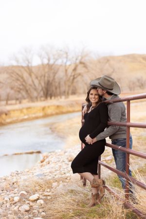 Maternity photoshoot intimate moment western attire rustic fence Missouri River Fort Benton Chouteau County Montana Great Falls photography