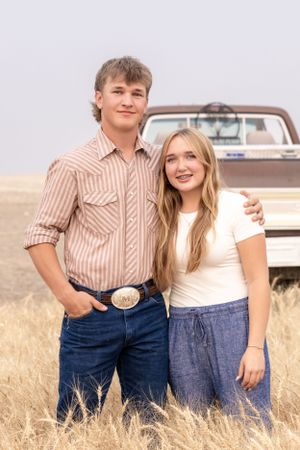 Brother and sister in family wheat field in Chouteau County, showcasing genuine grins photography
