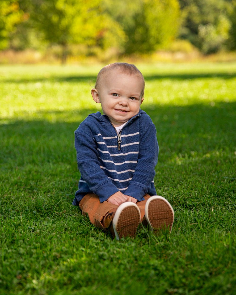 baby sitting in grass smiling