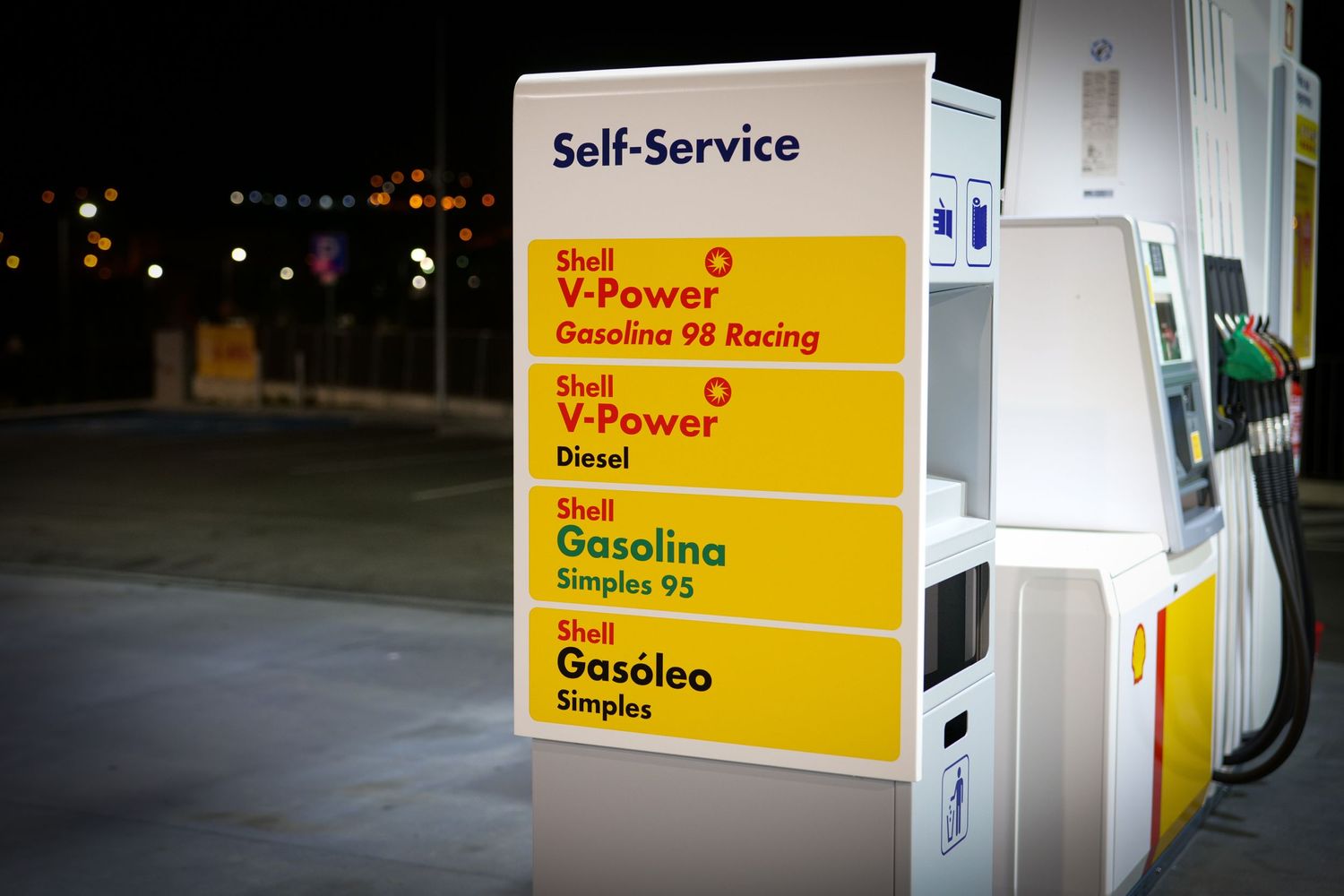 Shell self-service fuel pump sign displaying V-Power 98 Racing, Diesel, Gasoline 95, and Gasoleo options.