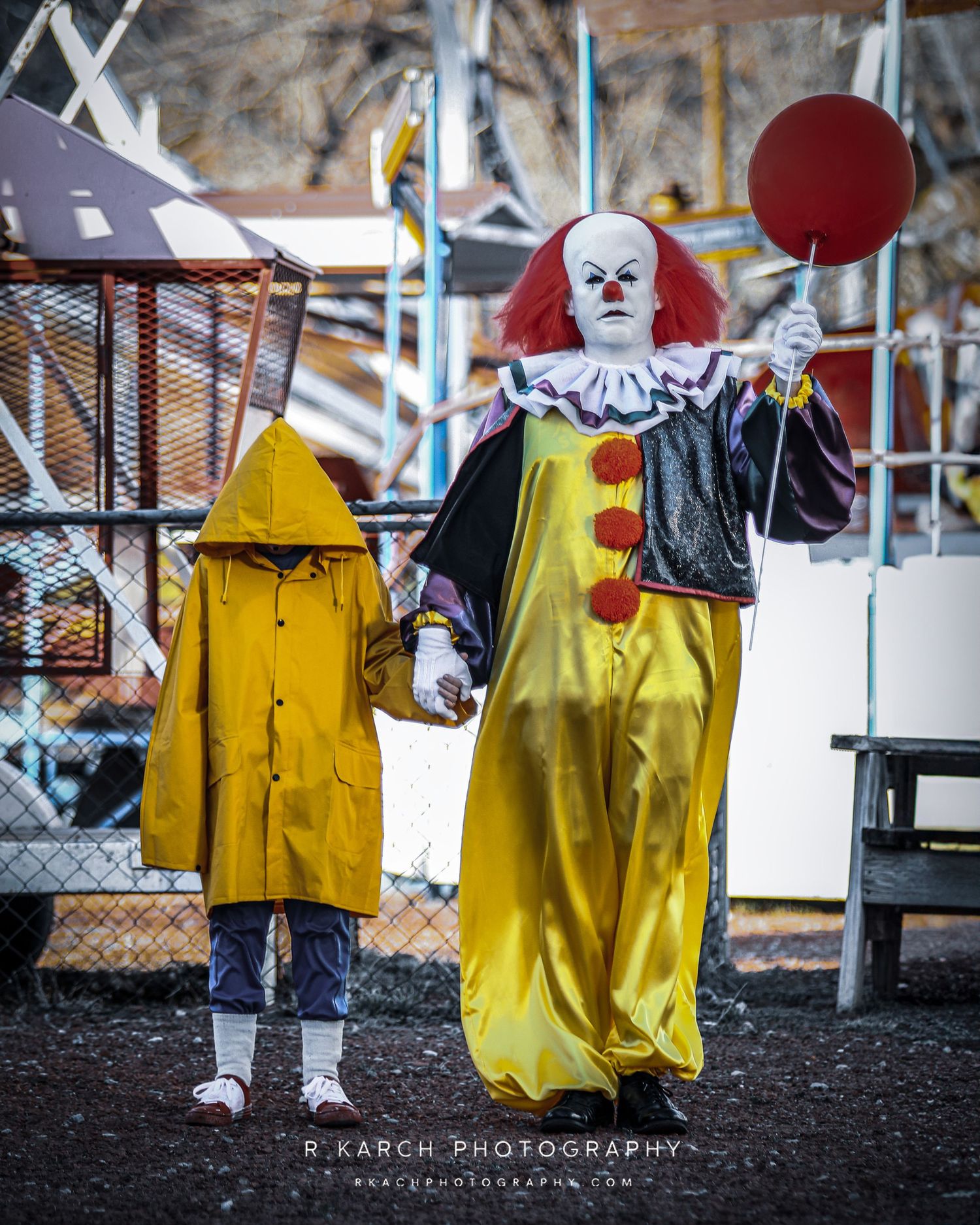 A creepy clown costume and yellow raincoat display create an eerie carnival atmosphere.