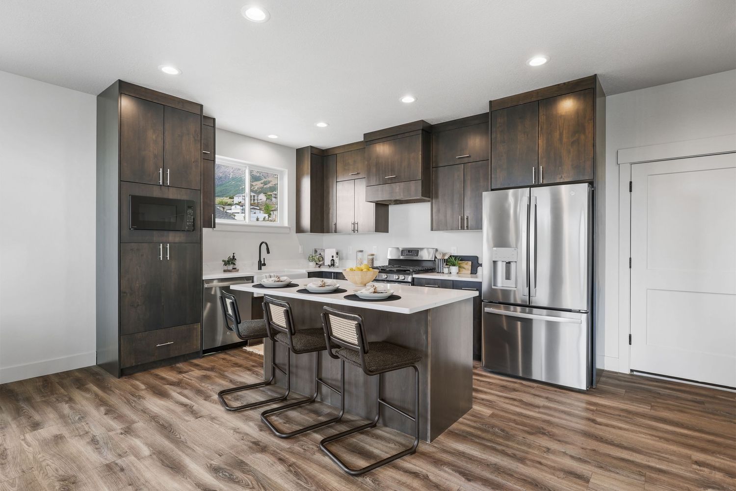 Modern craftsman home with white and brick exterior, green lawn, mountain views.