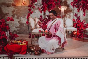 Traditional Hindu ceremony setup with red floral decorations and candlelight.