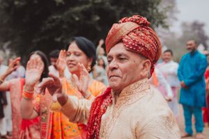 Participants in traditional Indian attire celebrate during an outdoor ceremony.