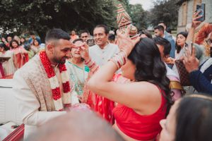 Wedding guests celebrate during a traditional Indian baraat ceremony outdoors.