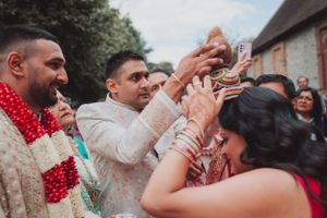 Celebratory moment during a traditional Indian wedding ceremony with guests throwing colorful powder.