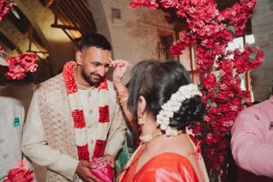 Traditional Indian wedding ceremony with bright pink floral decorations.