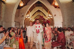 A joyous celebration moment during a wedding ceremony in an architectural venue with arched ceilings.
