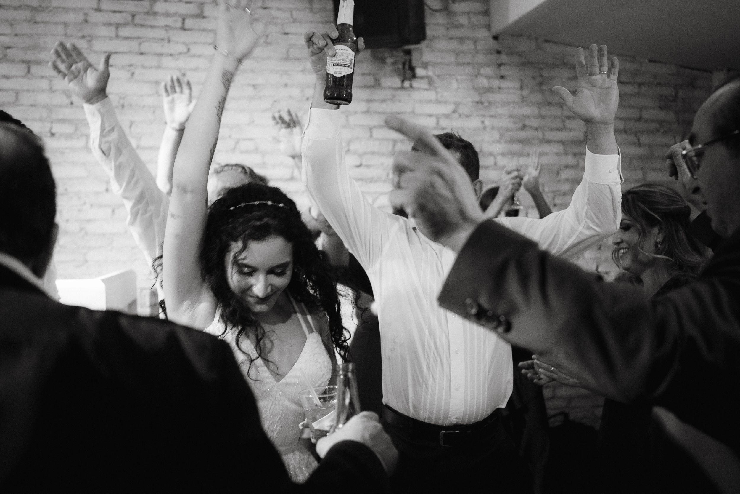 Celebration on a dance floor with partygoers dancing beneath ambient lighting in an indoor venue.