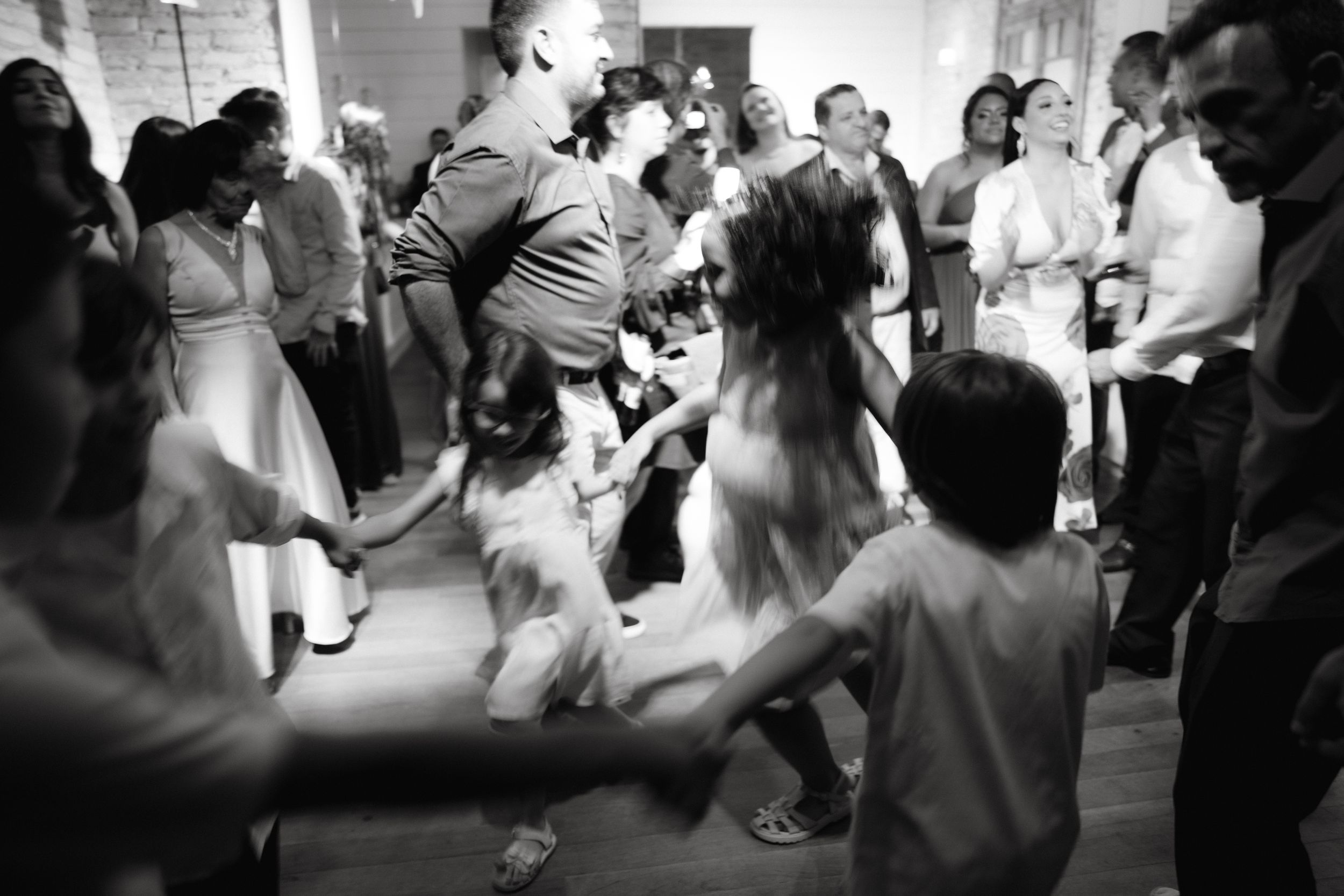 People enjoying themselves on a dance floor during a wedding celebration with dynamic lighting effects.