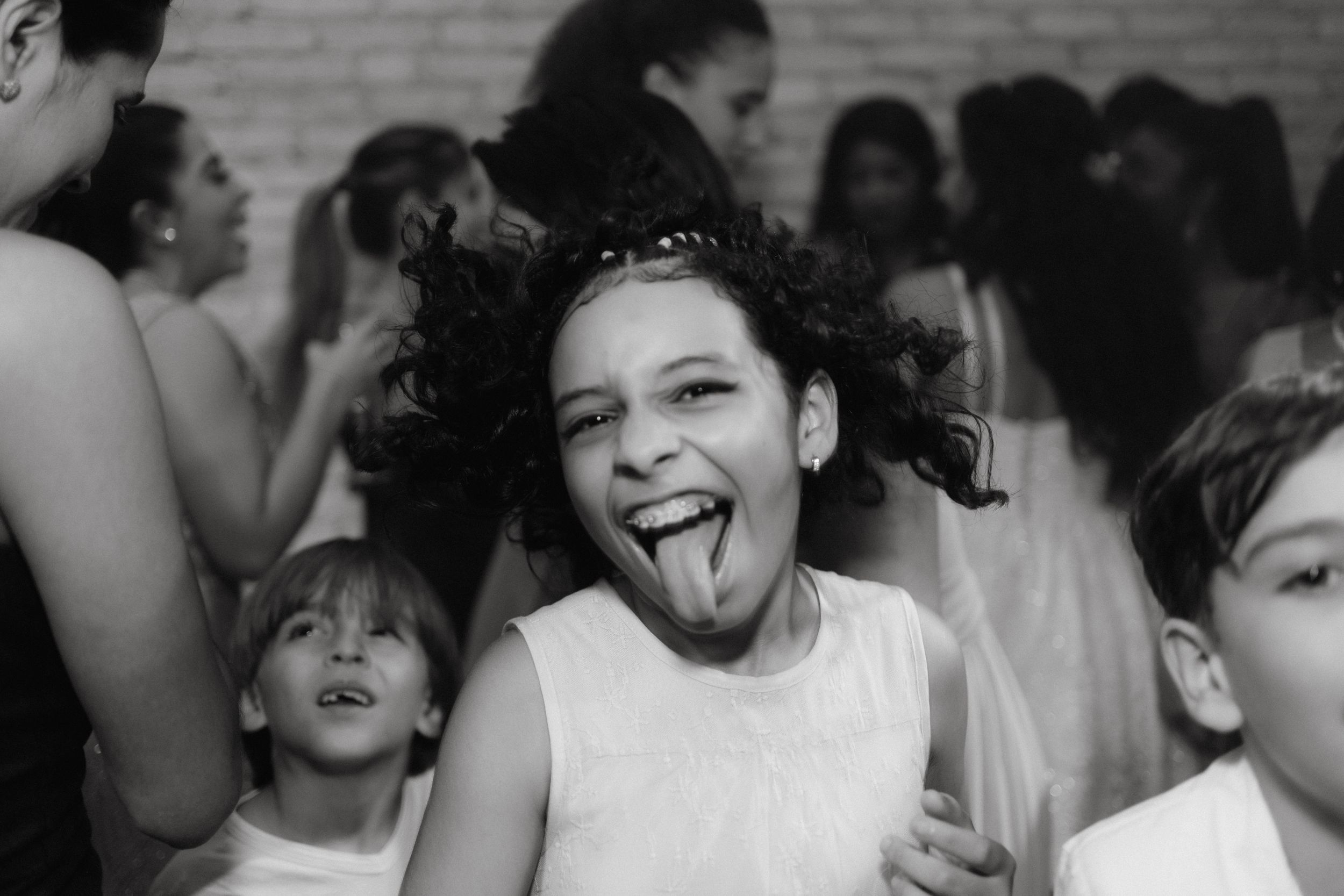 Party guests enjoying themselves on a dance floor with expressive dance moves and joyful energy.