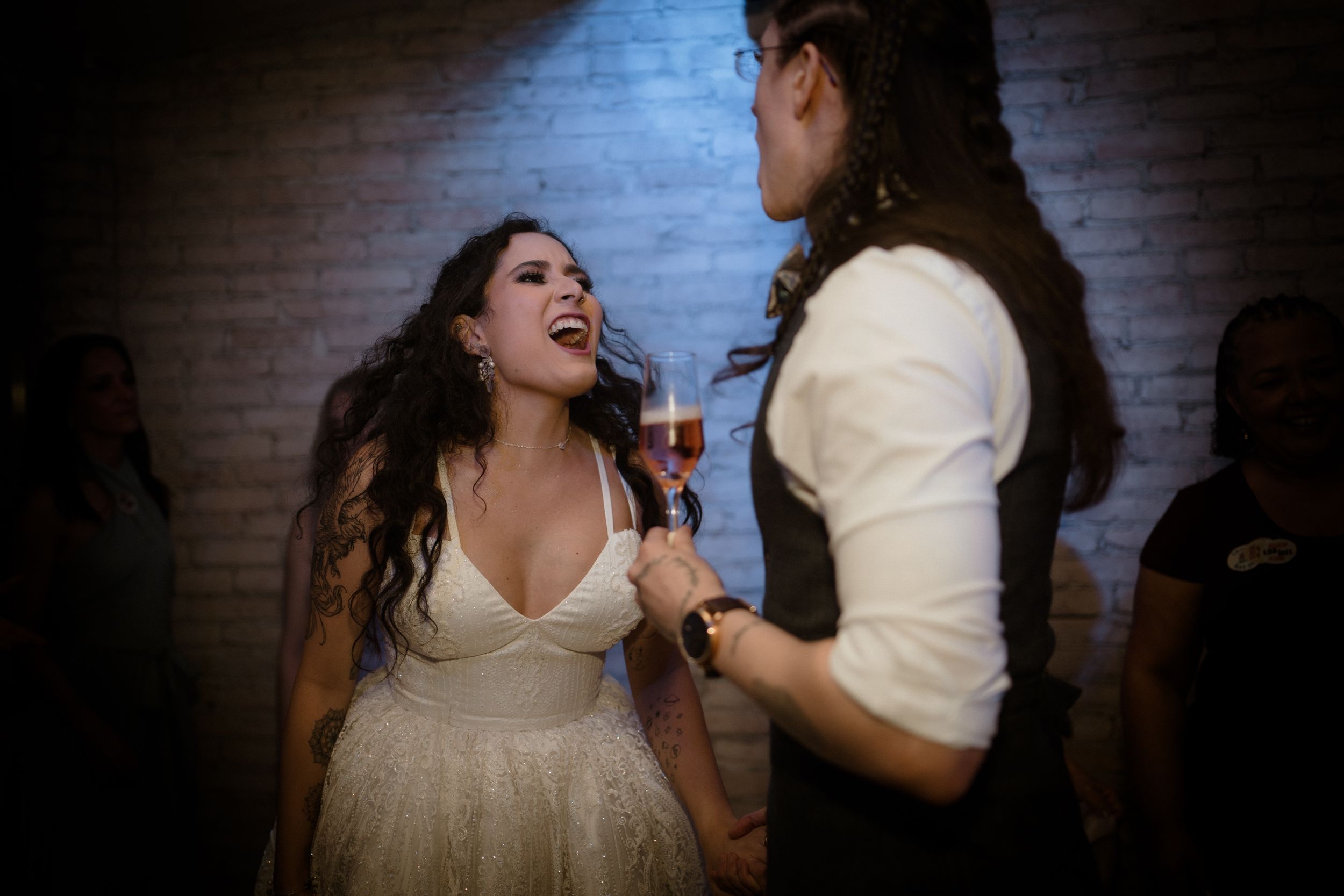 Dance floor scene at a wedding reception with dramatic lighting and energetic atmosphere.