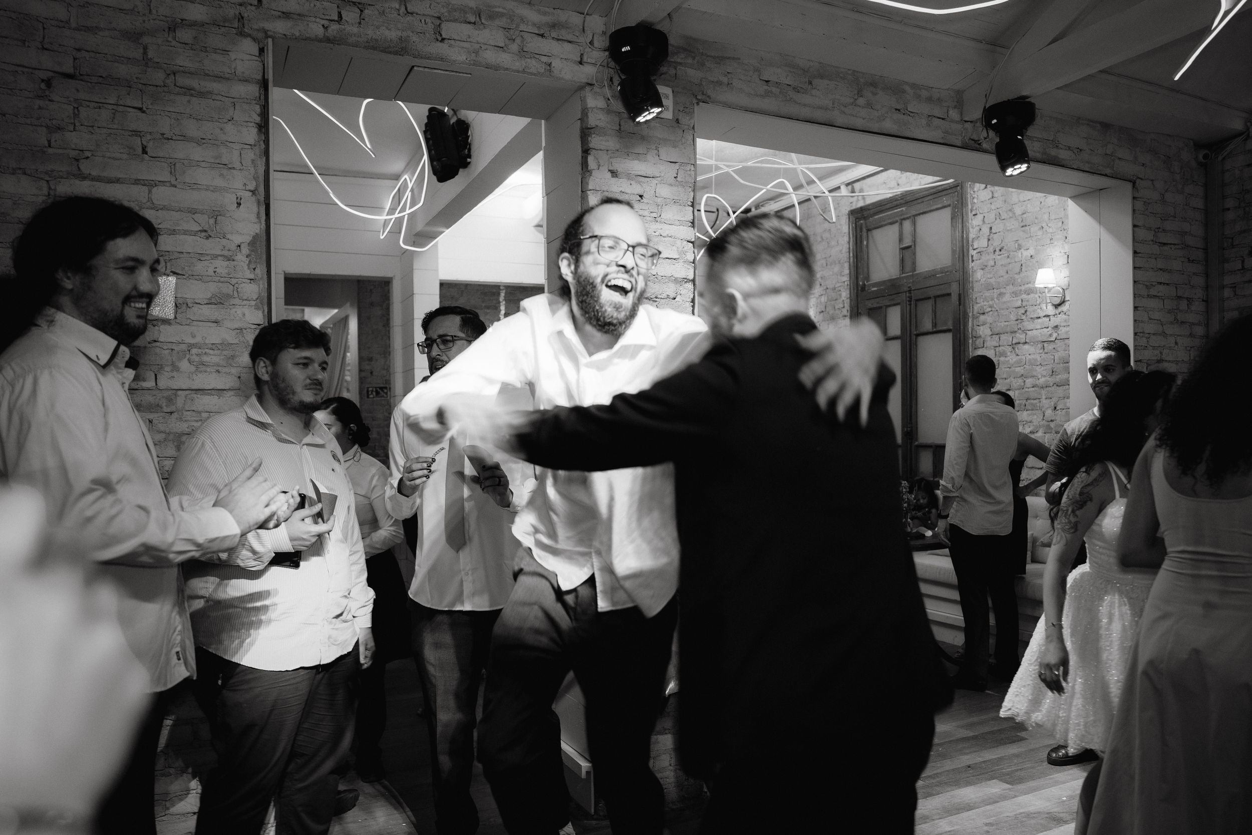 Dance party scene with people celebrating in a dimly lit indoor venue.