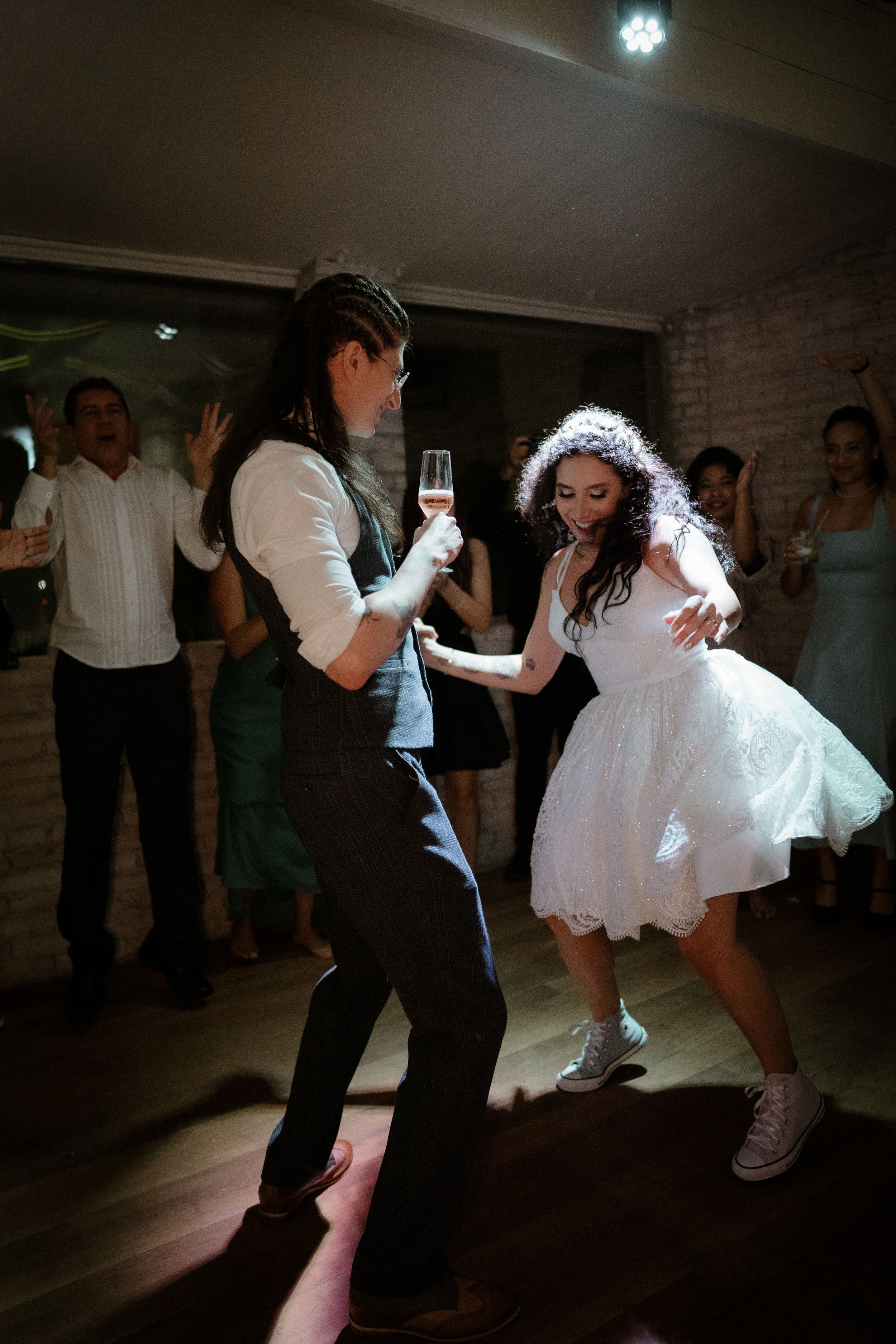 Wedding reception dance floor with guests celebrating in formal attire.