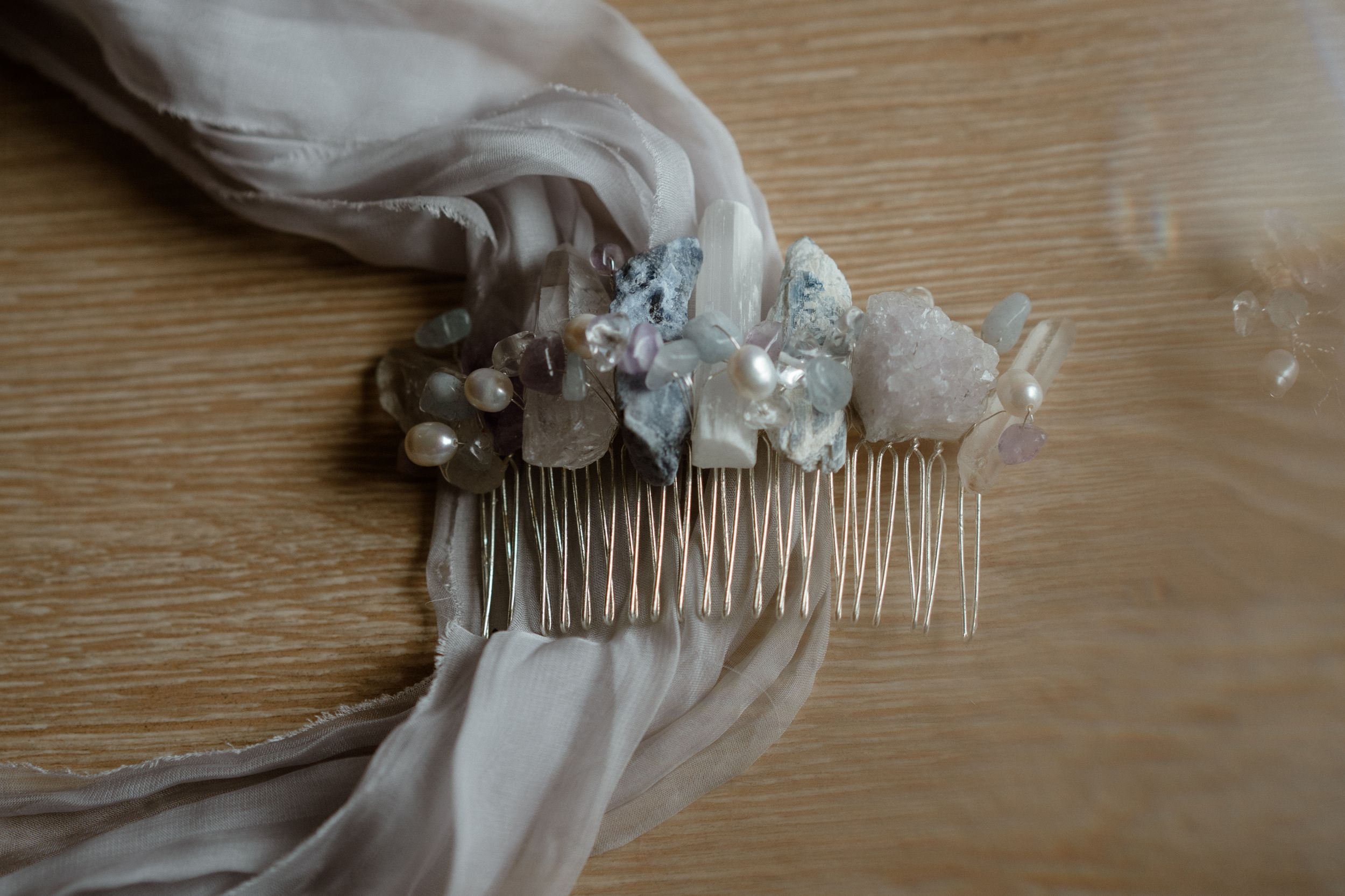 Delicate bridal hair accessory with pearls and crystals attached to a silk fabric.