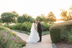 Newlyweds share a romantic moment in a garden at sunset with blooming flowers at the Dallas Arboretum's a Tasteful Place