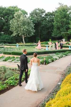 A couple walking through a manicured garden with stone pathways and yellow flowers at the Dallas Arboretum's a Tasteful Place